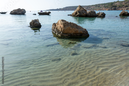 Crystal clear blue water of Mediterranean sea and yellow rocks in on Konnos beach near Protaras, Cyprus