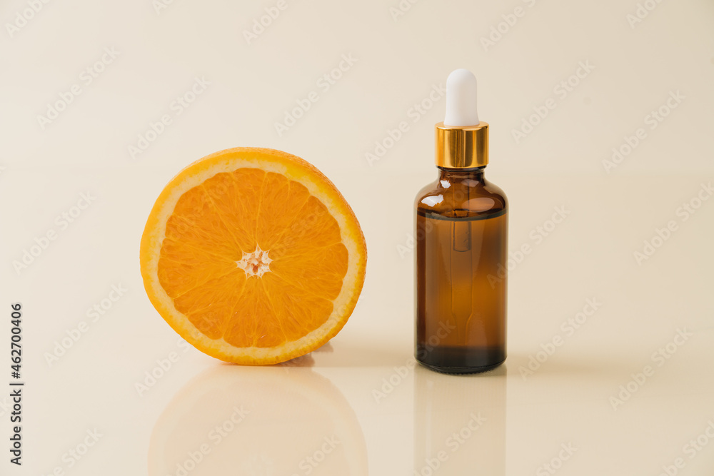 Vitamin C serum in cosmetic transparent bottle with dropper, sliced orange close-up view. Facial skin care concept. Natural organic cosmetics beauty Vitamin C serum in cosmetic transparent bottle with dropper, sliced orange close-up view. Facial skin care concept. Natural organic cosmetics beauty