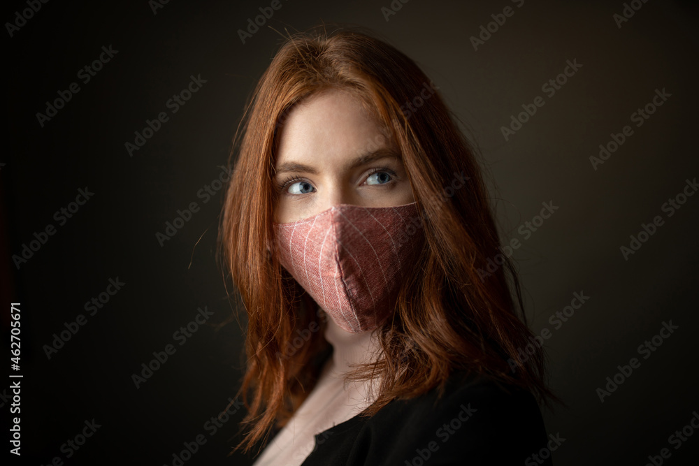 Pretty woman with protective mask in studio