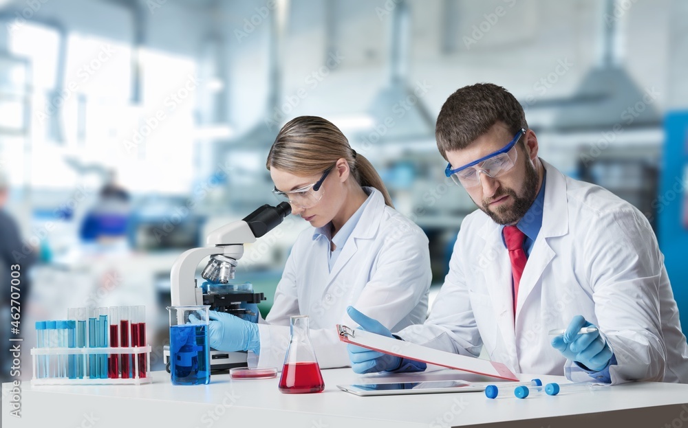 Scientist analyzing microscope slide at laboratory, a biopsy in the laboratory of cancer research Scientist analyzing microscope slide at laboratory, a biopsy in the laboratory of cancer research