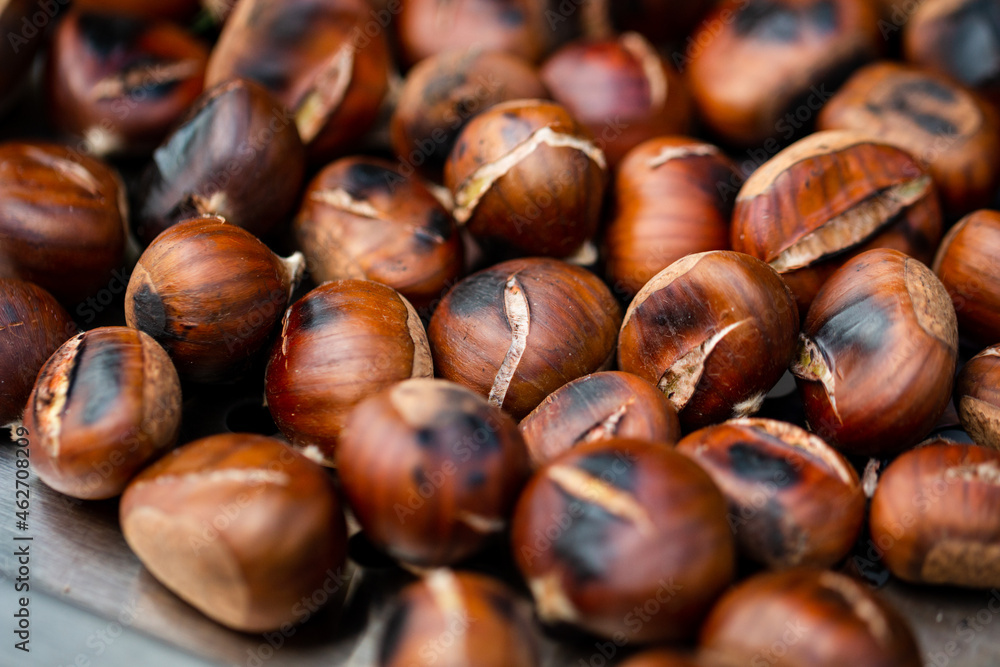 Group of beautifully roasted chestnuts on metal plate
