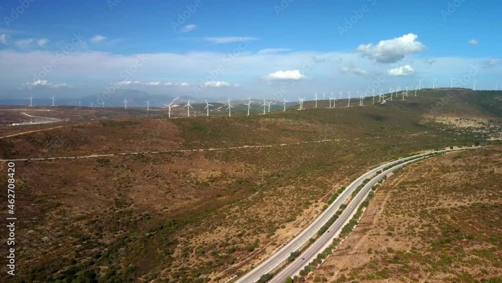 Aerial view over the farm landscape and wind turbines generating clean renewable energy. Renewable energy production for the green ecological world. High quality 4k footage Aerial view over the farm landscape and wind turbines generating clean renewable energy. Renewable energy production for the green ecological world. High quality 4k footage
