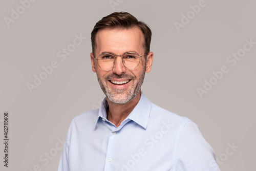 Closeup portrait of handsome elegant businessman in eyeglasses looking at the camera and smiling.