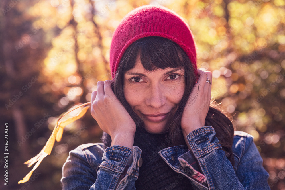 Woman wearing red woolly hat and denim jacket Woman wearing red woolly hat and denim jacket