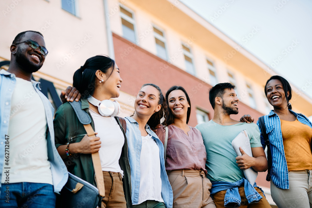 Below view of multiracial group of happy college friends at campus. Below view of multiracial group of happy college friends at campus.