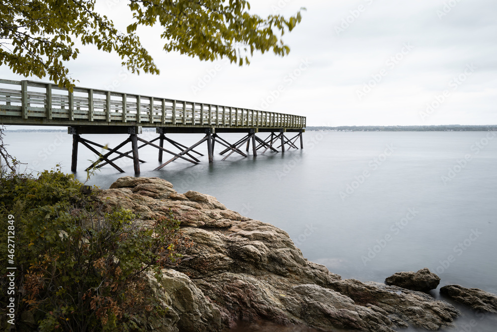 Pier and jetty at New Haven Harbor in Connecticut. Tranquil seascape with the view of long boardwalk dock in New Haven.