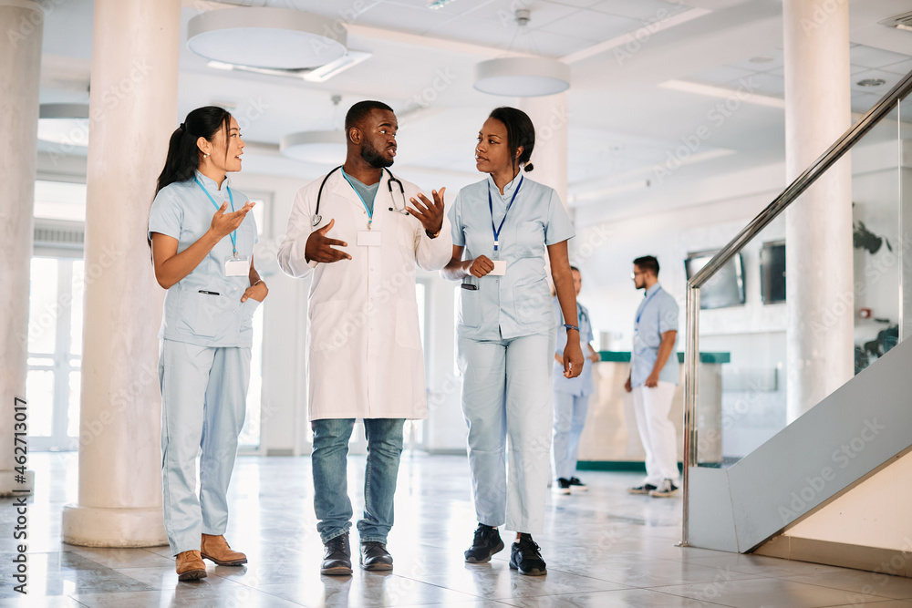 Group of young students talk while walking through medical university hallway. Group of young students talk while walking through medical university hallway.