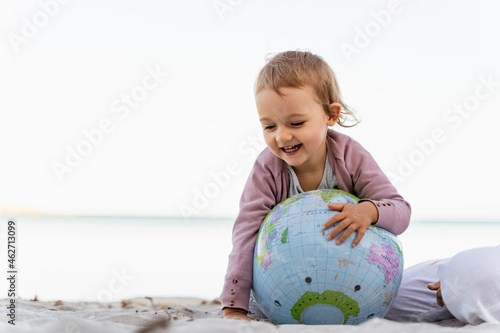 Portrait of happy little girl playing with  Earth beach ball