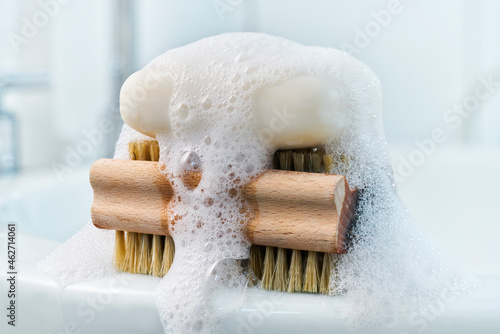 Soap, foam and brush on bathroom sink photo