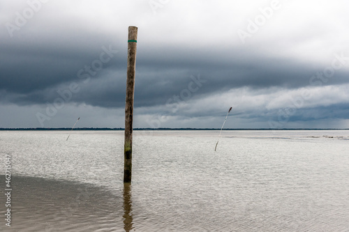 Germany, Nessmersiel, wooden stake in the sea