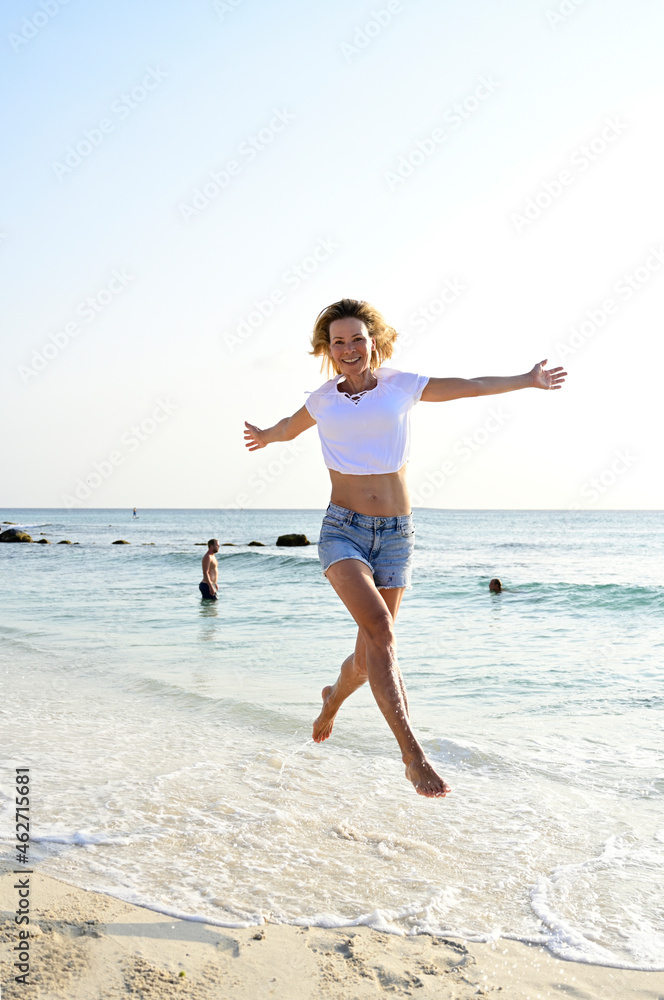 Beautiful woman running and jumping for joy on the beach Beautiful woman running and jumping for joy on the beach