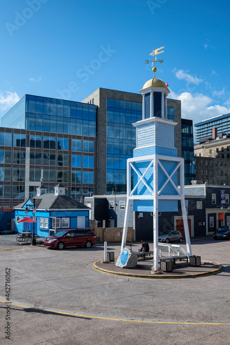 Canada, Nova Scotia, Halifax, Dockyard Clock standing against modern building