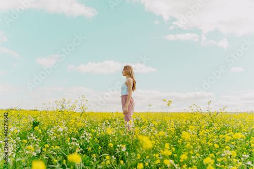 Young woman standing in a flower meadow in spring photo