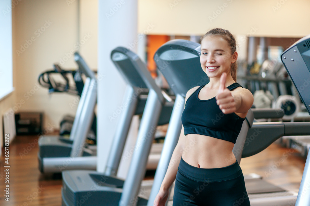 A young woman is engaged in fitness at the GYM. A woman on a treadmill. A young woman is engaged in fitness at the GYM. A woman on a treadmill.