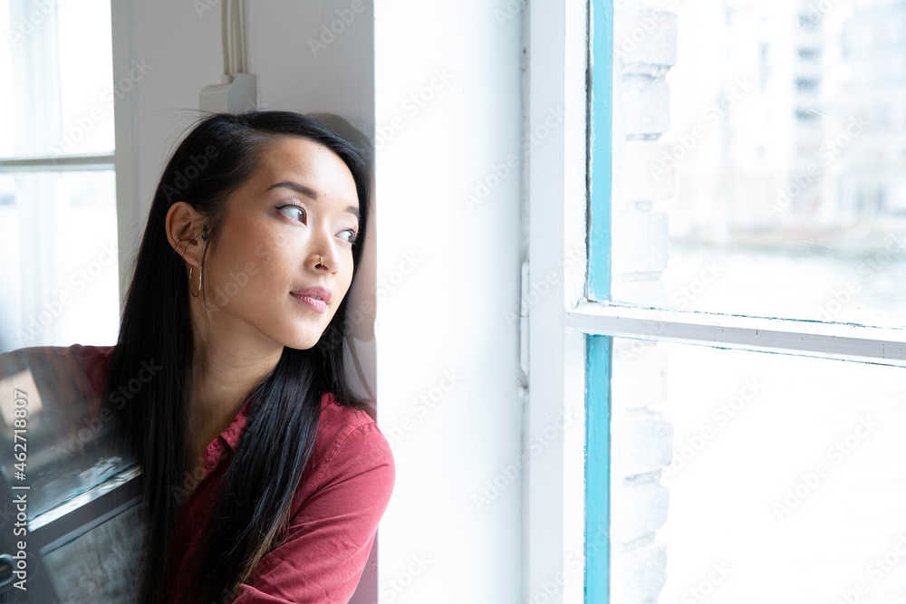 Portrait of woman looking out of window in office Portrait of woman looking out of window in office