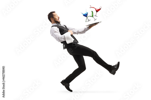 Full length profile shot of a waiter falling with a tray of cocktails photo