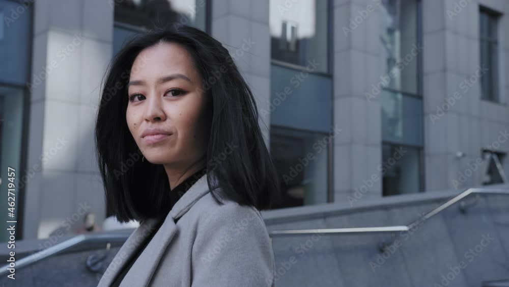 Young adult asian woman shaking her hair and looking at camera Young adult asian woman shaking her hair and looking at camera