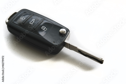 Isolated white background of black modern car key. Close up car key fob. © Anatoliy