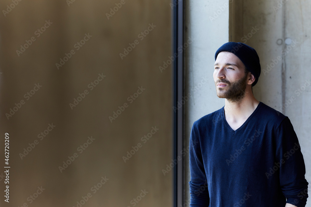 Young man wearing beanie looking out of window Young man wearing beanie looking out of window