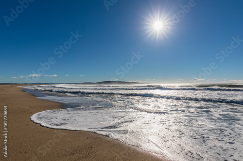 New Zealand, Kaka Point, Sun shining over sandy coastal beach photo