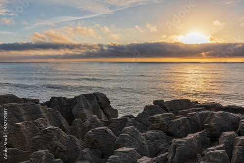 New Zealand, Buller District, Punakaiki, Limestone Pancake Rocks formation and coastal blow hole at sunset photo