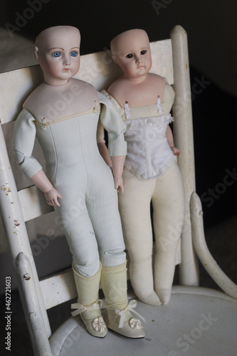 Fotografering Pair of Vintage dolls on vintage chair - doll parts