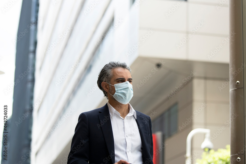 Businessman wearing protective mask in city Businessman wearing protective mask in city