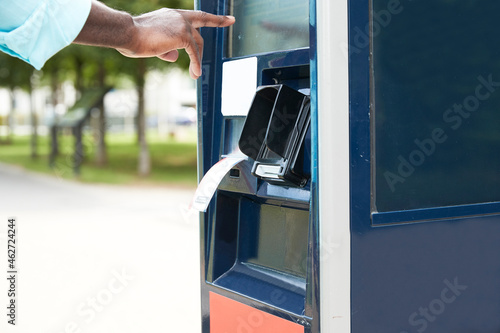 Hand of male commuter using ticket machine on sunny day photo