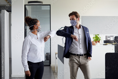 Colleagues greeting each other in office during Corona crisis