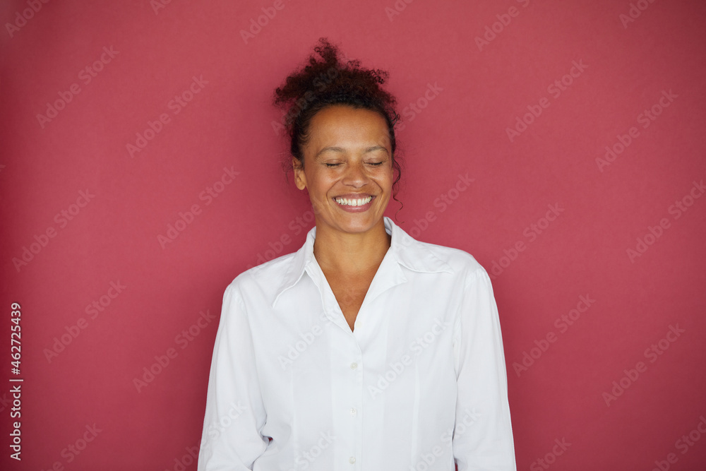 Portrait of smiling businesswoman with eyes closed against red background Portrait of smiling businesswoman with eyes closed against red background