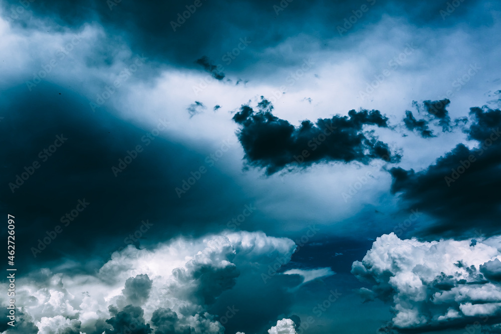 Fototapeta premium White clouds against a dark bright blue sky. Cloudy wallpaper for news about weather forecast. Before a thunderstorm and hurricane or storm. The power and strength of nature. Air element. Religion