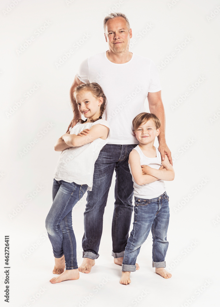 Portrait of father with two children standing in front of white background Portrait of father with two children standing in front of white background