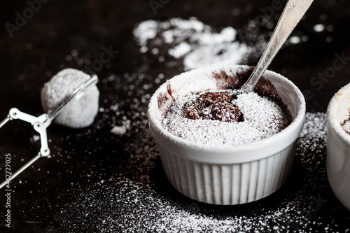 Studio shot of mug of molten chocolate cake with powdered sugar photo