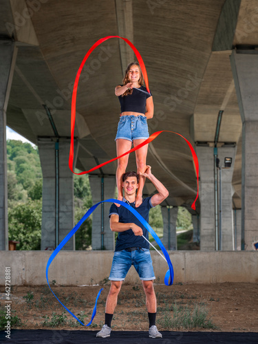 Young couple doing acrobatics with fitness band
