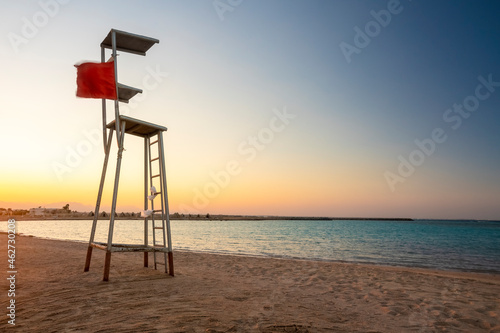 Egypt, Hurghada, Empty lifeguard chair standing on sandy coastal beach of Sahl Hasheesh bay at sunset photo