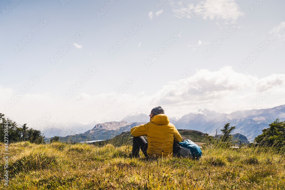 Man looking at view while sitting on mountain at Patagonia, Argentina, South America Man looking at view while sitting on mountain at Patagonia, Argentina, South America