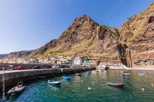 Portugal, Madeira Island, Paul do Mar, Fishing boats moored in harbor, mountain and town in background photo