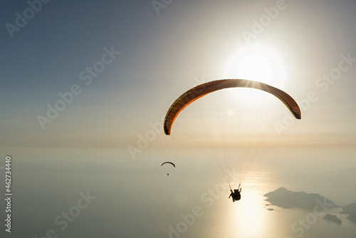 Paragliding over the sea during sunset