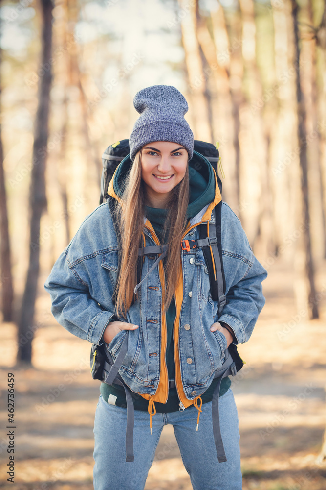 Caucasian white girl with a large hiking backpack in the forest. Autumn colors Caucasian white girl with a large hiking backpack in the forest. Autumn colors