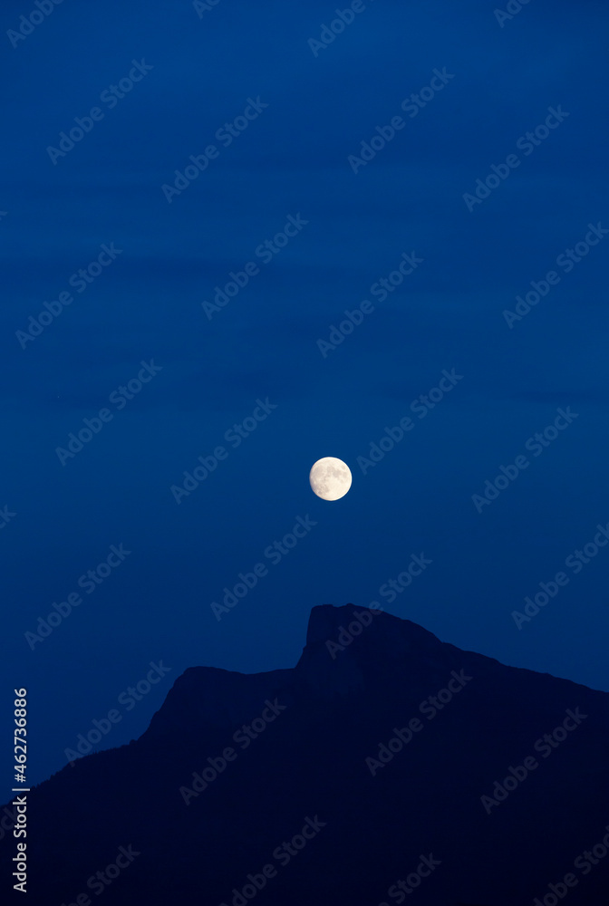 Full moon glowing over silhouette of Schafberg mountain at night Full moon glowing over silhouette of Schafberg mountain at night