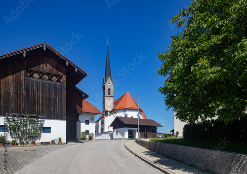 Germany, Bavaria, Saaldorf-Surheim, Road stretching in front of church in rural town photo