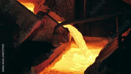 Foundry mechanism is pouring molten copper into a mold photo