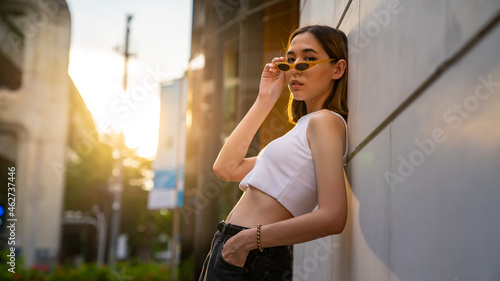 Portrait of Young beautiful Asian woman holding coffee cup walking down city street and shopping at downtown district. Pretty girl enjoy urban outdoor weekend activity lifestyle and city life.