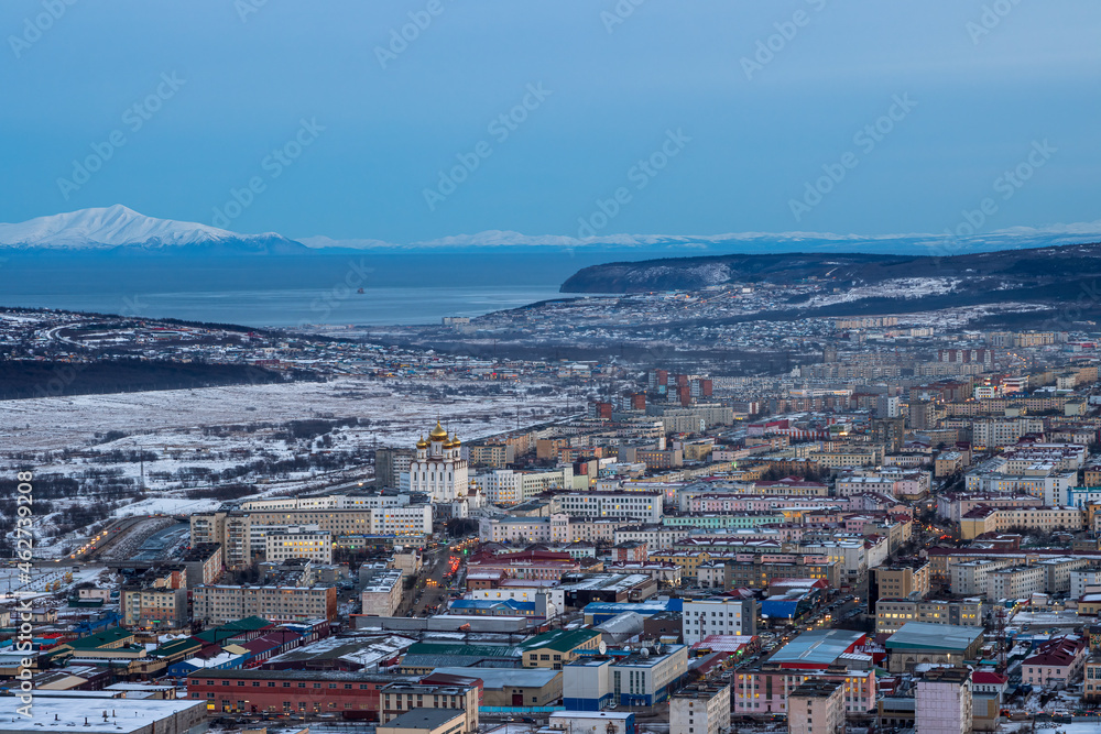 Evening view of the city of Magadan. Northern Russian city on the coast of the Sea of ​​Okhotsk. Winter cityscape. Aerial view of the streets and buildings. Magadan, Magadan region, Siberia, Russia.