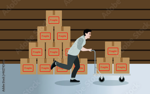 Man pushing cart with cardboard boxes, man running with merchandise cart, Side view of a young delivery man walking with a cart with boxes along the warehouse aisle