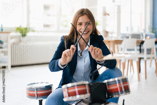 Young businesswoman playing percussion photo