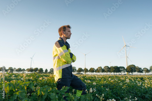 Engineer standing in a field at a wind farm photo