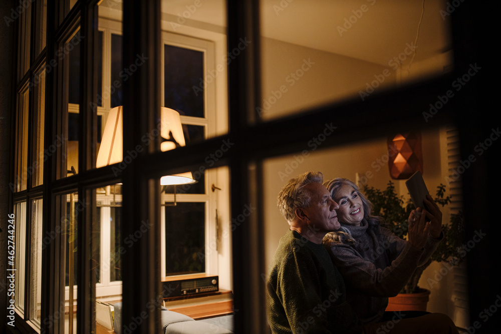 Senior couple using tablet at home at night Senior couple using tablet at home at night