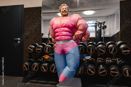Proud man wearing pink bodybuilder costume in gym