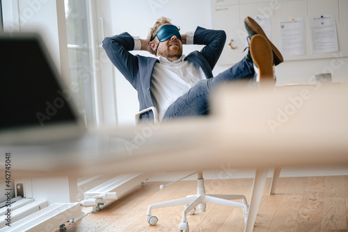 Businessman having a power nap at desk in office